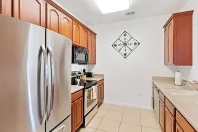 a kitchen with wooden cabinets and a stainless steel refrigerator at 4814 Cayview Avenue 406 in Orlando