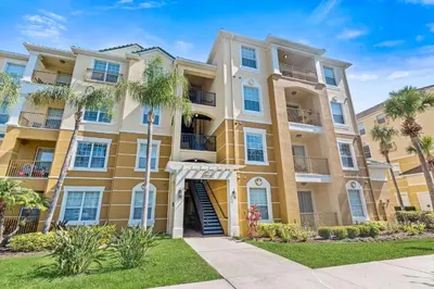 a large apartment building with palm trees in front of it at 4814 Cayview Avenue 406 in Orlando