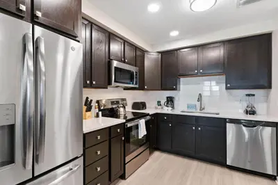 a kitchen with wooden cabinets and a stainless steel refrigerator at 4012 Breakview Drive 110 in Orlando