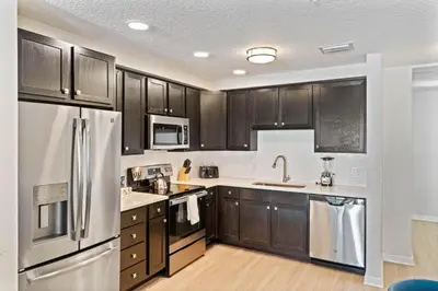 a kitchen with wooden cabinets and stainless steel appliances at 4012 Breakview Drive 410 in Orlando