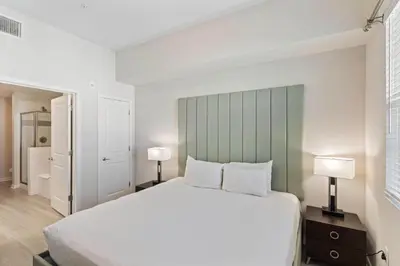 a bedroom with a large white bed with two lamps at 4012 Breakview Drive 410 in Orlando