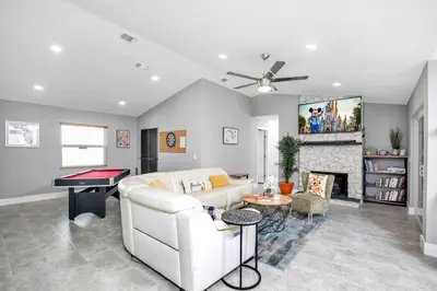 a living room with a white couch and a pool table at Home away from home in Orlando! in Orlando