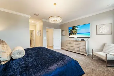 a large bedroom with a blue bed and a couch at New Beautiful 7 br w pool games theme rooms in Kissimmee
