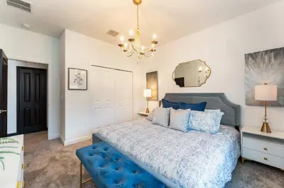 a bedroom with a blue bed and a chandelier at New Beautiful 7 br w pool games theme rooms in Kissimmee