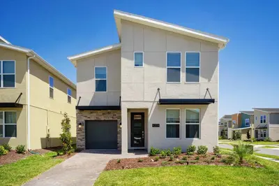 a large white house with a garage at New Beautiful 7 br w pool games theme rooms in Kissimmee