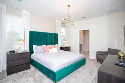a bedroom with a large bed with a green headboard at 4577 Stunning 7 bedroom home in Kissimmee