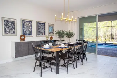 a dining room with a table and chairs and a pool at 4577 Stunning 7 bedroom home in Kissimmee