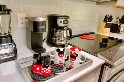 a kitchen counter with cups and a coffee maker at Cozy & Magical place sleeps 12/10 min from Disney in Kissimmee