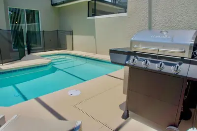 a swimming pool with a grill and a swimming pool at Cozy & Magical place sleeps 12/10 min from Disney in Kissimmee