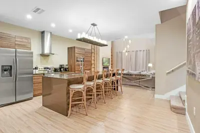 a kitchen with a bar with chairs and a refrigerator at Beautiful 4 suites - Close to Disney 7505 in Orlando