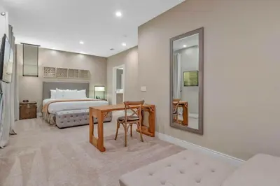 a bedroom with a bed and a table and a mirror at Beautiful 4 suites - Close to Disney 7505 in Orlando