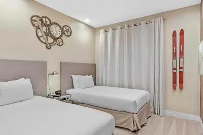 two beds in a hotel room with snowboards on the wall at Beautiful 4 suites - Close to Disney 7505 in Orlando
