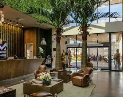 a lobby with palm trees and chairs in a mall at Beautiful 4 suites - Close to Disney 7505 in Orlando