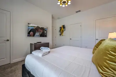 a white bedroom with a large white bed in it at Relax in Style at this Spacious 4-Bedroom Villa in Kissimmee