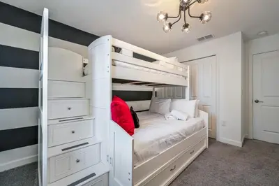 a bedroom with a white bunk bed with white cabinets at Relax in Style at this Spacious 4-Bedroom Villa in Kissimmee