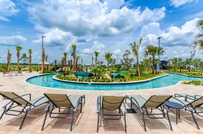 a pool at the resort with chairs and palm trees at 4813 Crusoe Street in Kissimmee