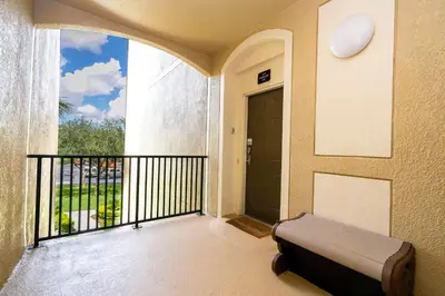 a balcony with a bench in front of a door at Dream Cozy 3BR Condo - Disney 5 Min Walk to Pool in Orlando