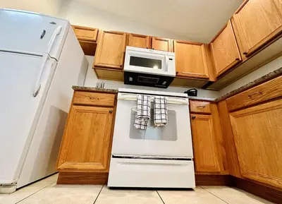 a kitchen with a white refrigerator and a microwave at Spacious, Open Layout And Pool Relaxation! in Orlando