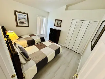 two beds in a room with two doors at Spacious, Open Layout And Pool Relaxation! in Orlando