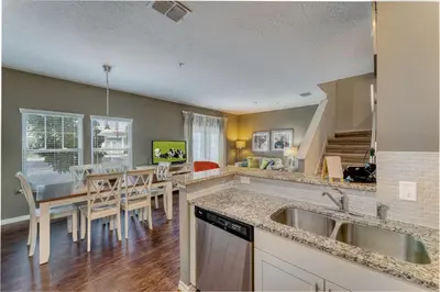a kitchen and dining room with a sink and a table at Happy Holiday Hideaway G in Kissimmee