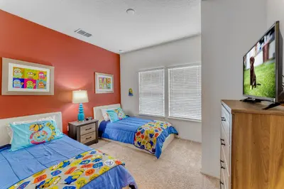 a bedroom with two beds and a flat screen tv at Happy Holiday Hideaway G in Kissimmee