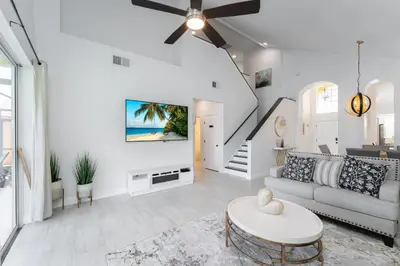 a white living room with a couch and a table at Lakeview Villa G in Orlando