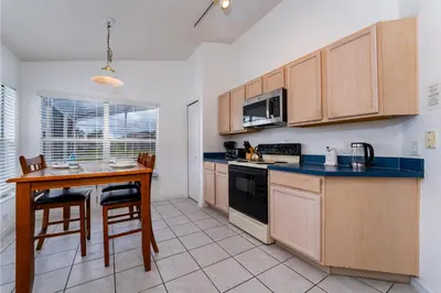 a kitchen with wooden cabinets and a table and chairs at Eagle's End S in Kissimmee