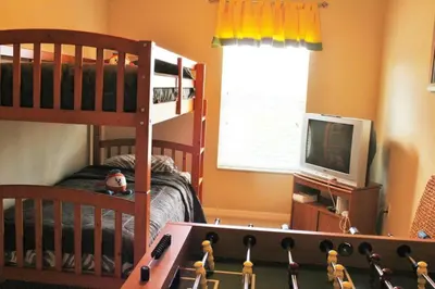 a childs bedroom with a bunk bed and a television at 4 bedroom townhouse Sleeps 8 Coral Cay in Kissimmee