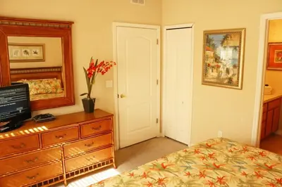 a bedroom with a bed and a dresser and a mirror at 4 bedroom townhouse Sleeps 8 Coral Cay in Kissimmee