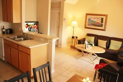 a kitchen and living room with a couch and a table at 4 bedroom townhouse Sleeps 8 Coral Cay in Kissimmee