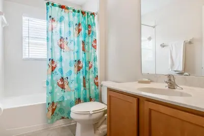 a bathroom with a toilet and a sink and a shower curtain at 6 bedrooms pool home Gated resort Veranda Palms in Kissimmee
