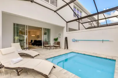 a swimming pool in a house with chairs and a table at 4 bedrooms pool home Hidden Forest Resort Amenities in Orlando