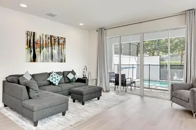 a living room with a couch and chairs and a large window at 4 bedrooms pool home Hidden Forest Resort Amenities in Orlando