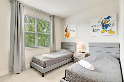 a bedroom with two beds and a window at 4 bedrooms pool home Hidden Forest Resort Amenities in Orlando
