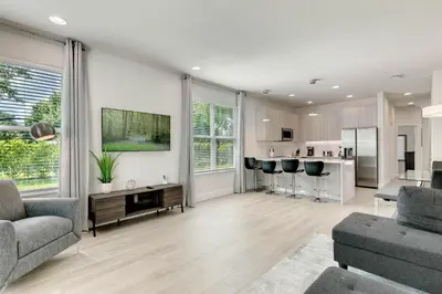 a living room with a couch and a kitchen at 4 bedrooms pool home Hidden Forest Resort Amenities in Orlando