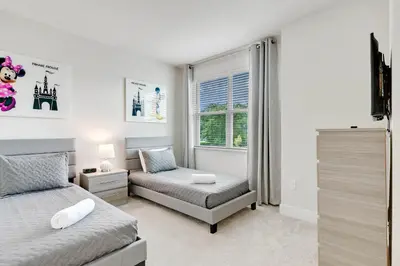 a bedroom with two beds and a window at 4 bedrooms pool home Hidden Forest Resort Amenities in Orlando