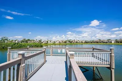 a wooden dock with two benches on a lake at LB4707AW 3 Bedroom Villa with pool and game room in Kissimmee