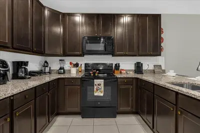 a kitchen with wooden cabinets and a stove top oven at 4732TH Cozy home in Kissimmee in Kissimmee