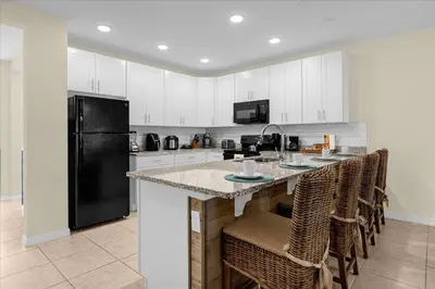 a kitchen with white cabinets and a black refrigerator at 3BD townhome near Disney 4730 in Kissimmee