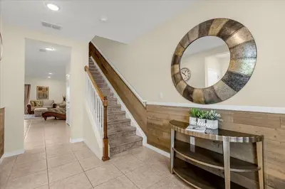 a living room with a staircase and a mirror at 3BD townhome near Disney 4730 in Kissimmee