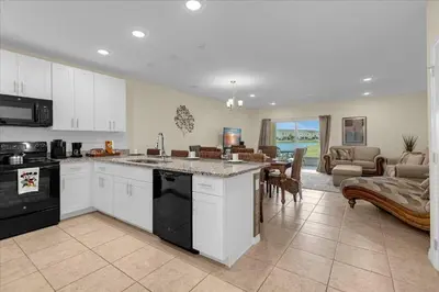 a kitchen and living room with a table and a couch at 3BD townhome near Disney 4730 in Kissimmee