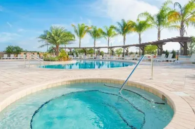 a pool at a resort with palm trees at Disney Dream Resort Amenities Pool *4BD/3BA* Close to Parks in Kissimmee