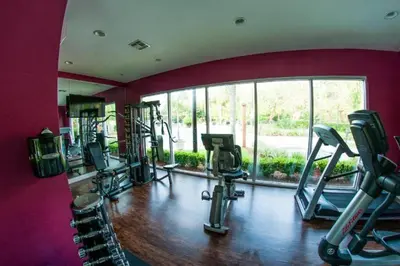 a gym with several tread machines and a large window at Disney Dream Resort Amenities Pool *4BD/3BA* Close to Parks in Kissimmee