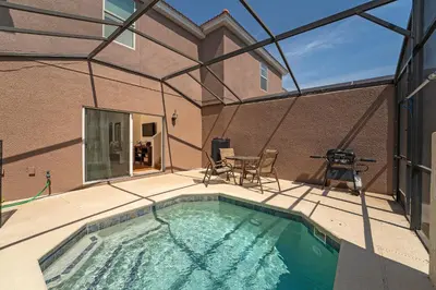 a swimming pool on a patio with a table and chairs at Pool Townhouse near to Disney - Bella Vida Resort in Kissimmee