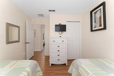 a bedroom with two beds and a dresser with a tv at Pool Townhouse near to Disney - Bella Vida Resort in Kissimmee