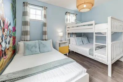 two bunk beds in a bedroom with blue walls at Modern 5 BDR Family Themed Home with Harry Potter Games Room and Free Pool Heat in Orlando