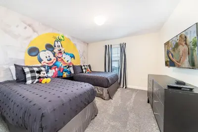 a bedroom with two beds and a tv in it at Magic villa with themed bedrooms and private pool in Kissimmee