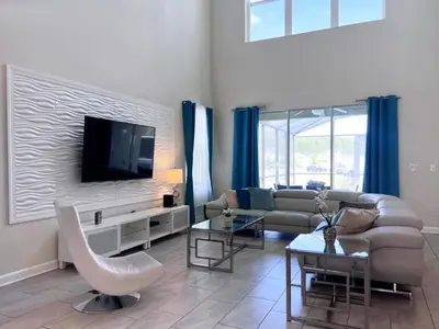 a living room with a couch and a tv at 5 Bed 5 Bath South Facing Pool Home Storey Lake home in Kissimmee