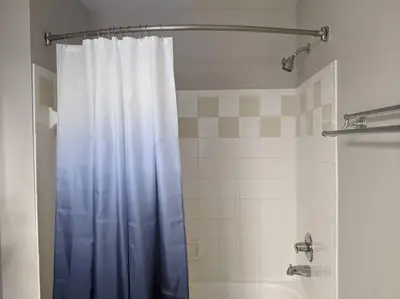 a bathroom with a shower with a blue shower curtain at Nice & Cozy - Vacation Home in Kissimmee