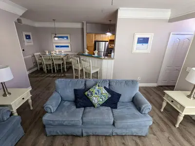 a living room with a blue couch and a kitchen at Nice & Cozy - Vacation Home in Kissimmee